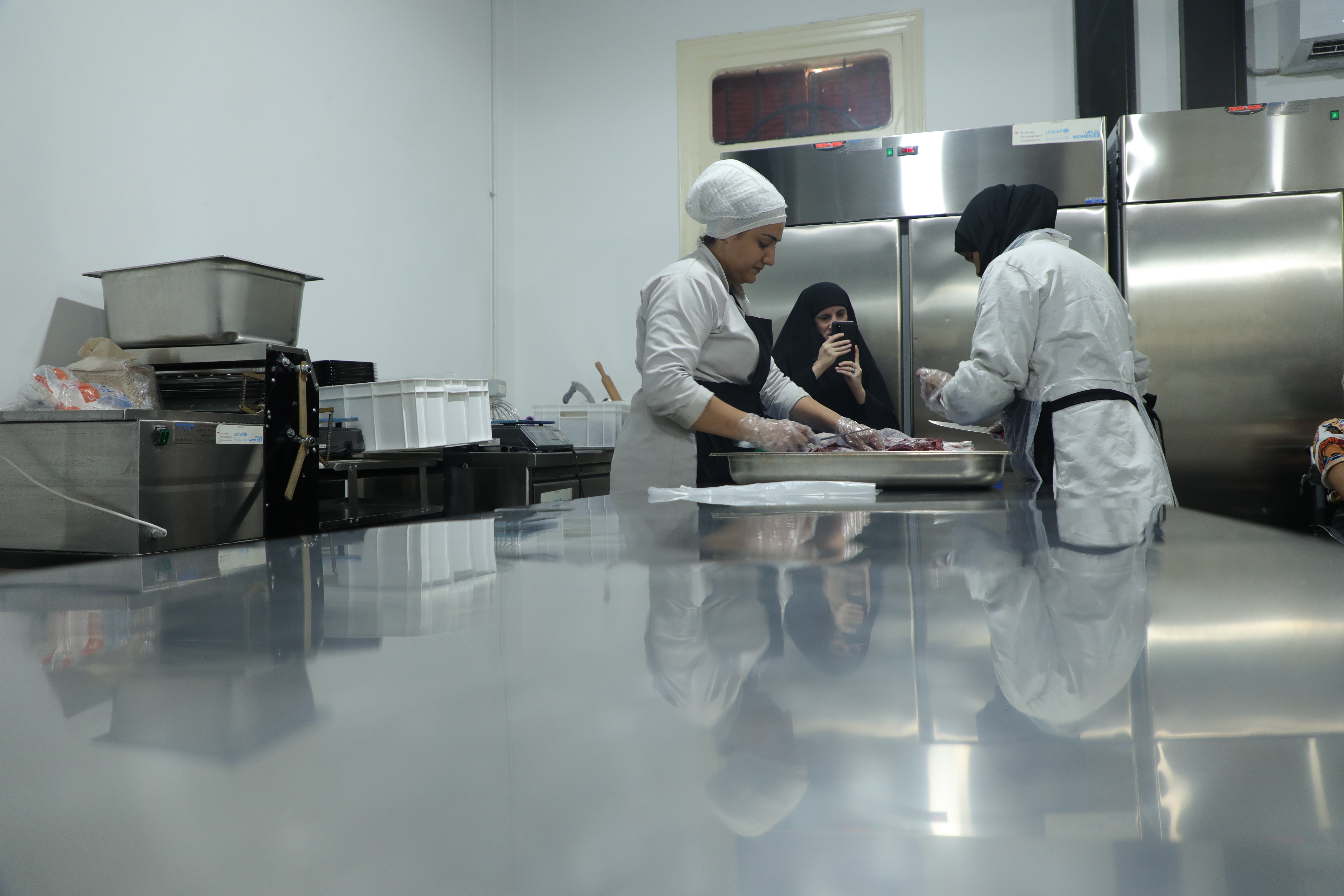 Three women slicing up meat